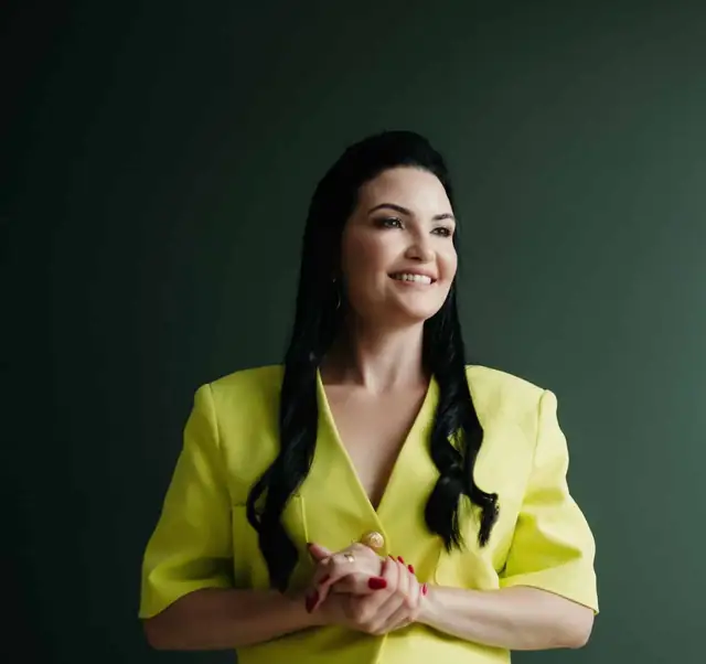 Advogada do escritório, sorrindo, de blazer verde-limão